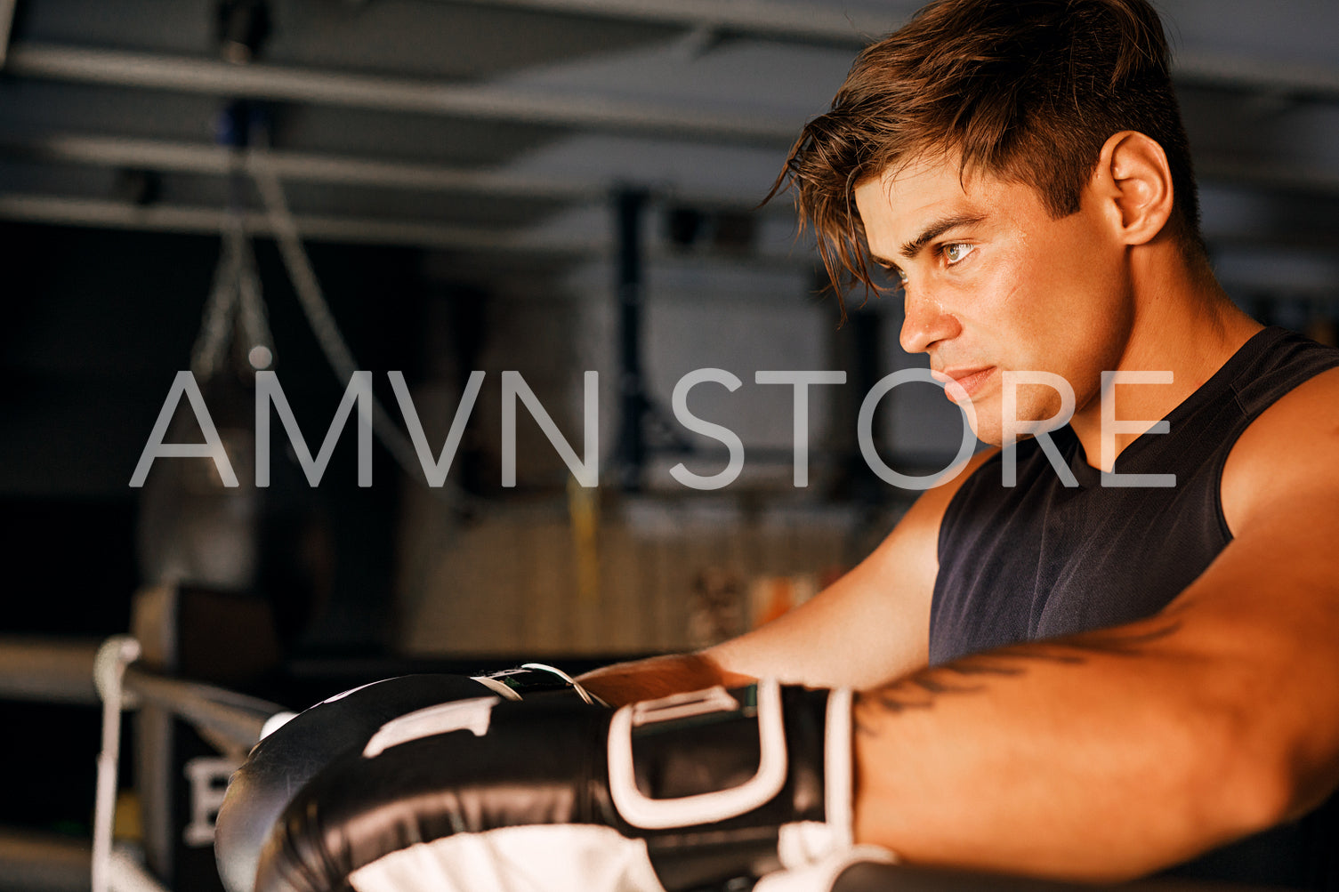 Side view of a boxer. Young athlete relaxing in ring.	