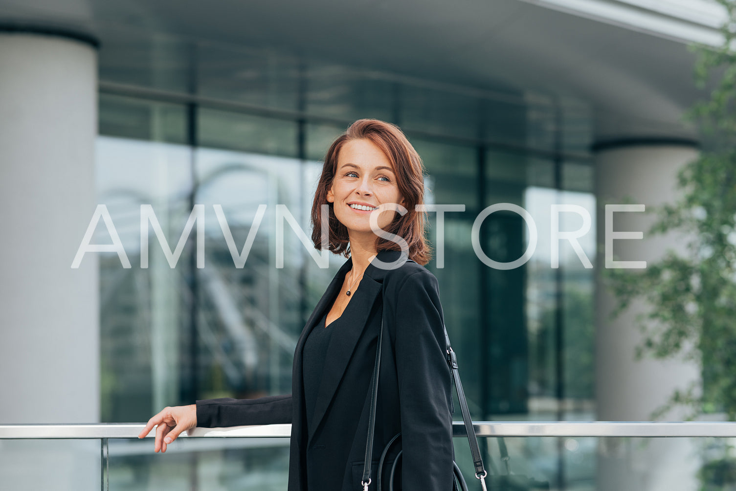 Smiling businesswoman with ginger hair looking away while standing outdoors