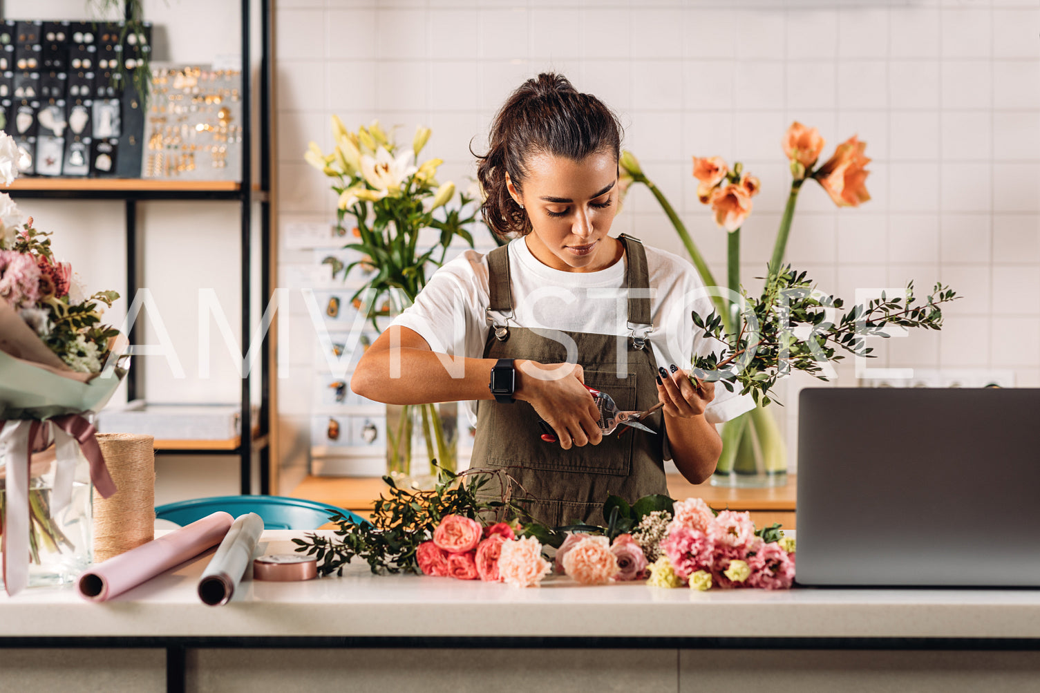 Female florist cutting stems in flower shop while standing at counter	