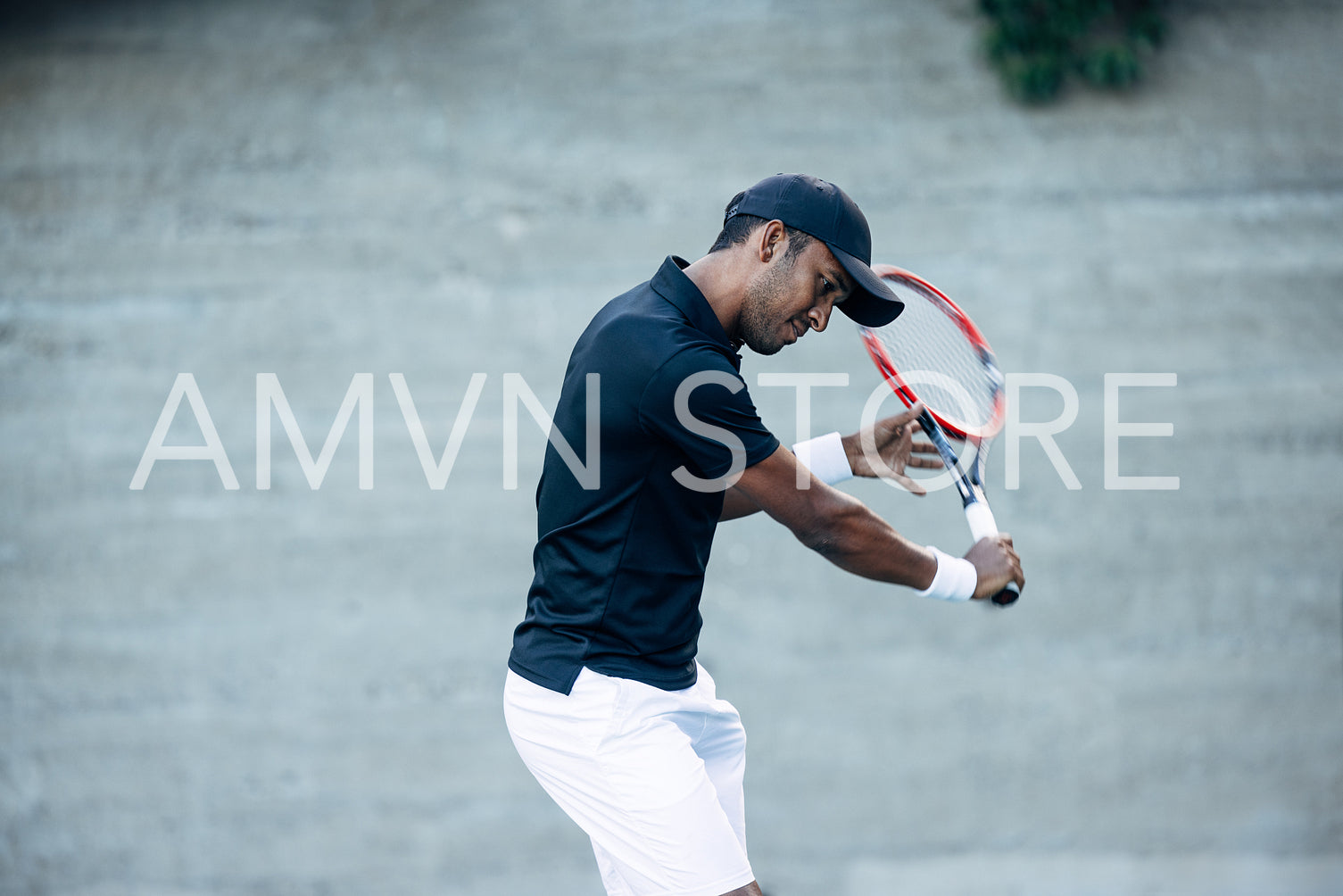 Young man in sportswear with a tennis racket playing outdoors