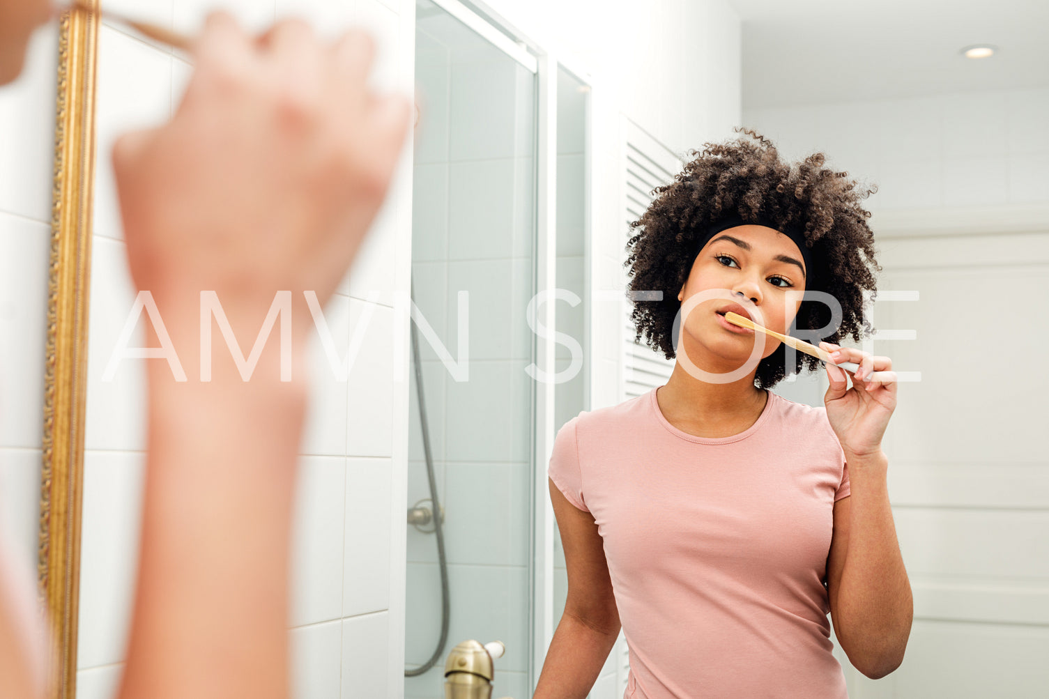 Reflection of a young woman in mirror brushing teeth	