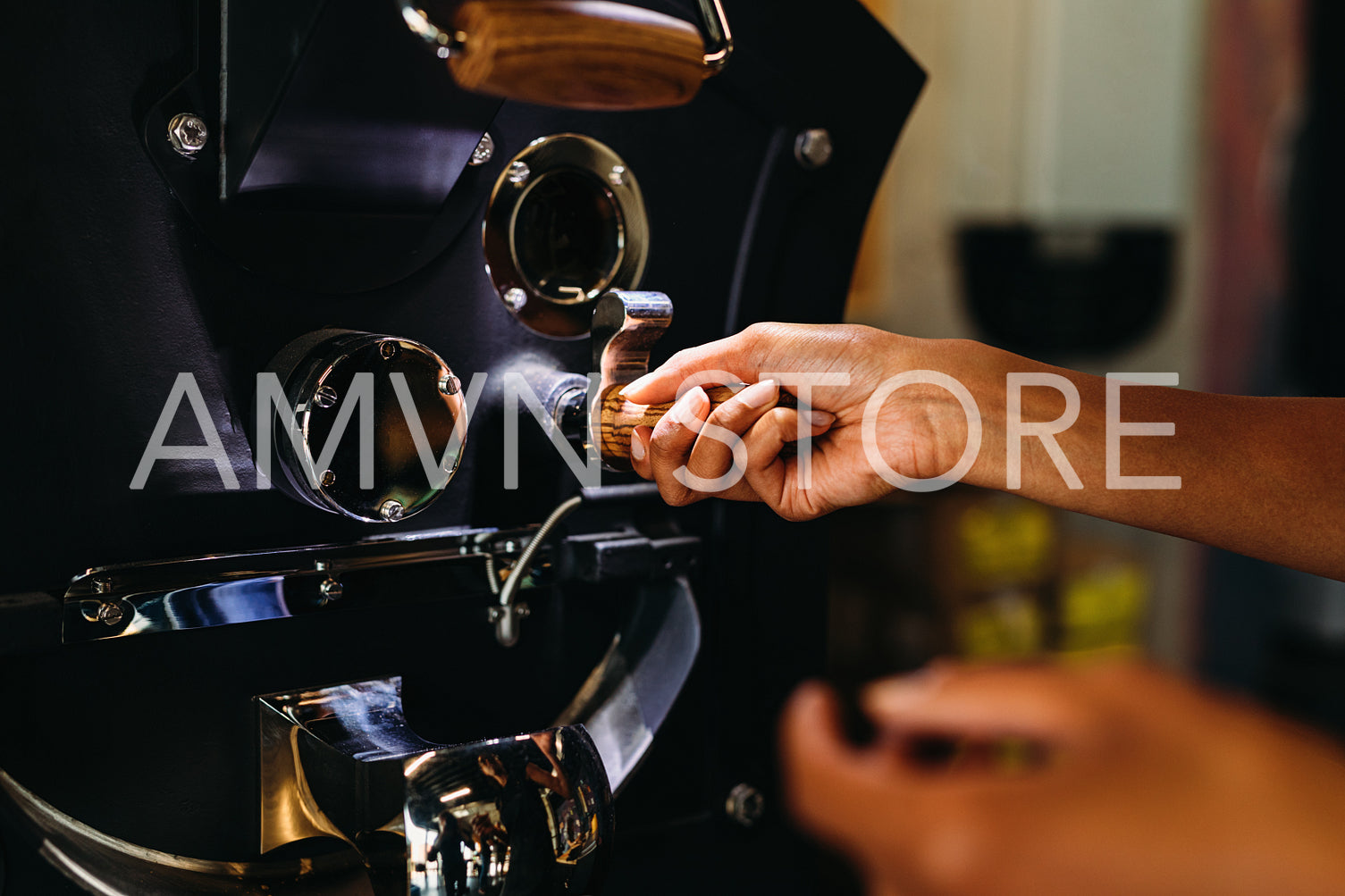 Close up of a woman hands pouring coffee beans into roaster	