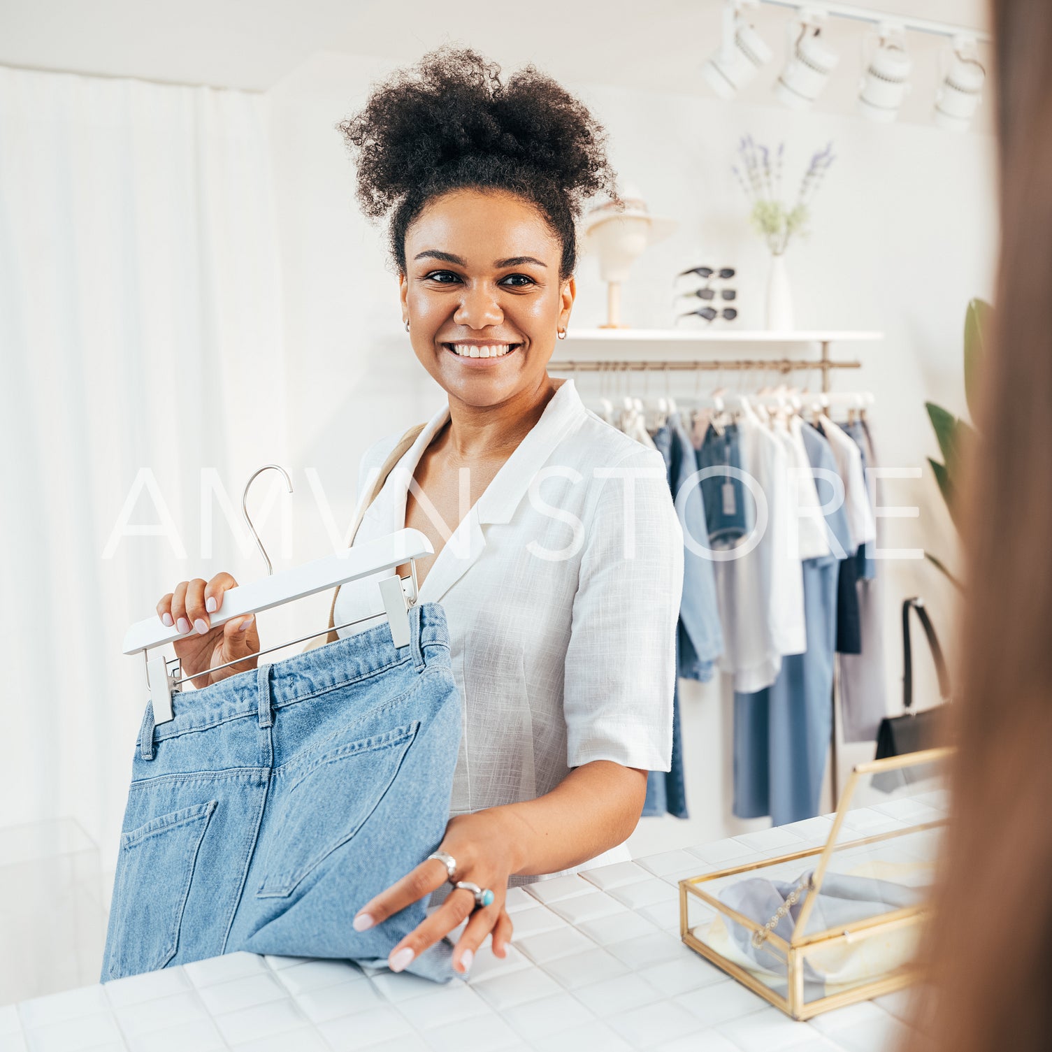 Portrait of a smiling customer standing with a hanger at the counter