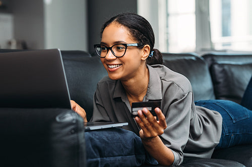 Beautiful woman making an online payment with credit card using laptop