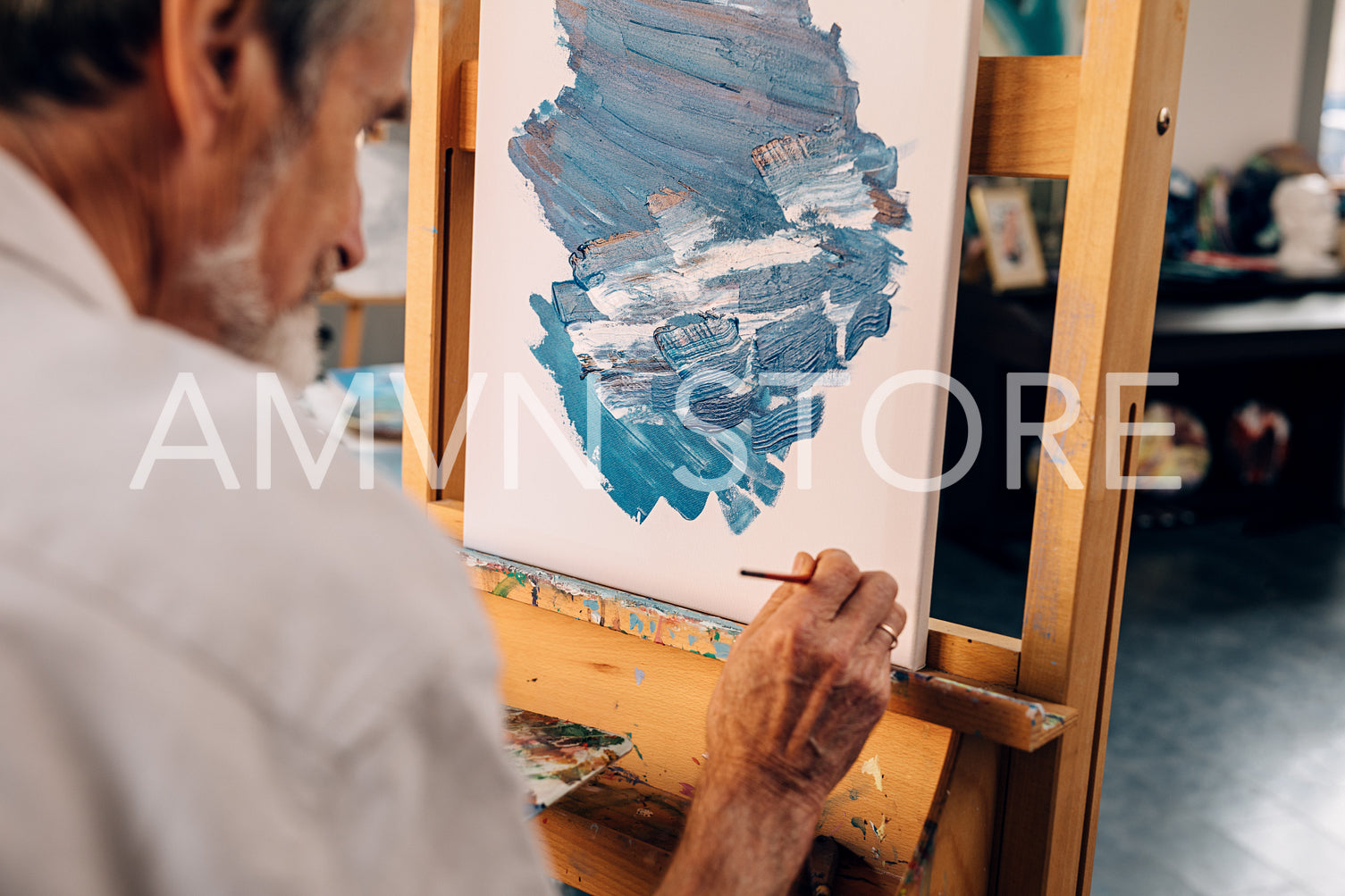 Senior artist making autograph on his abstract painting	