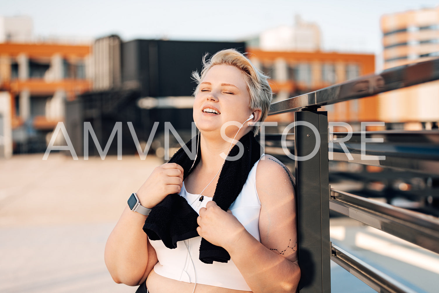 Smiling woman with plus size body holding a towel relaxing after workout	