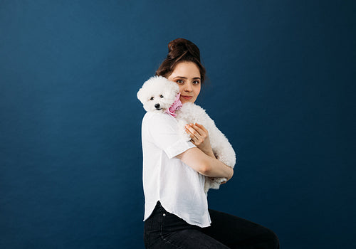 Portrait of a young woman with her white fluffy dog