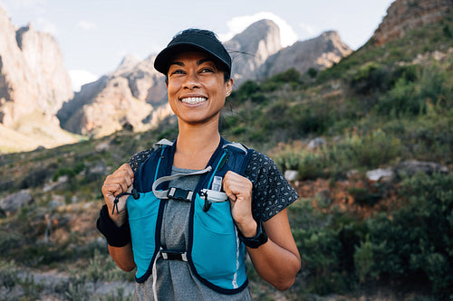 Portrait of a beautiful woman in sportswear standing in valley. Trail runner in sportswear standing outdoors.