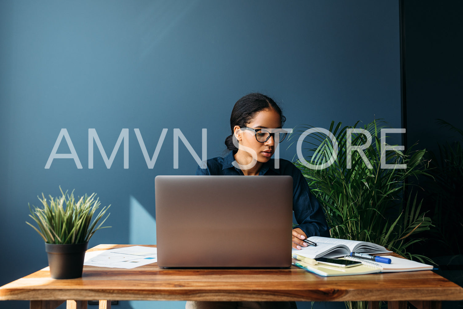 Thoughtful young woman looking at documents in home office. Entrepreneur working remotely.	