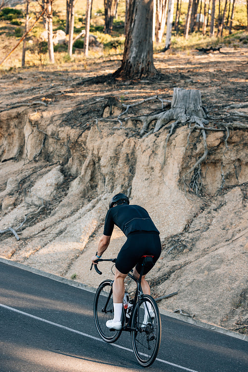 Back view of a male cyclist in black sports attire