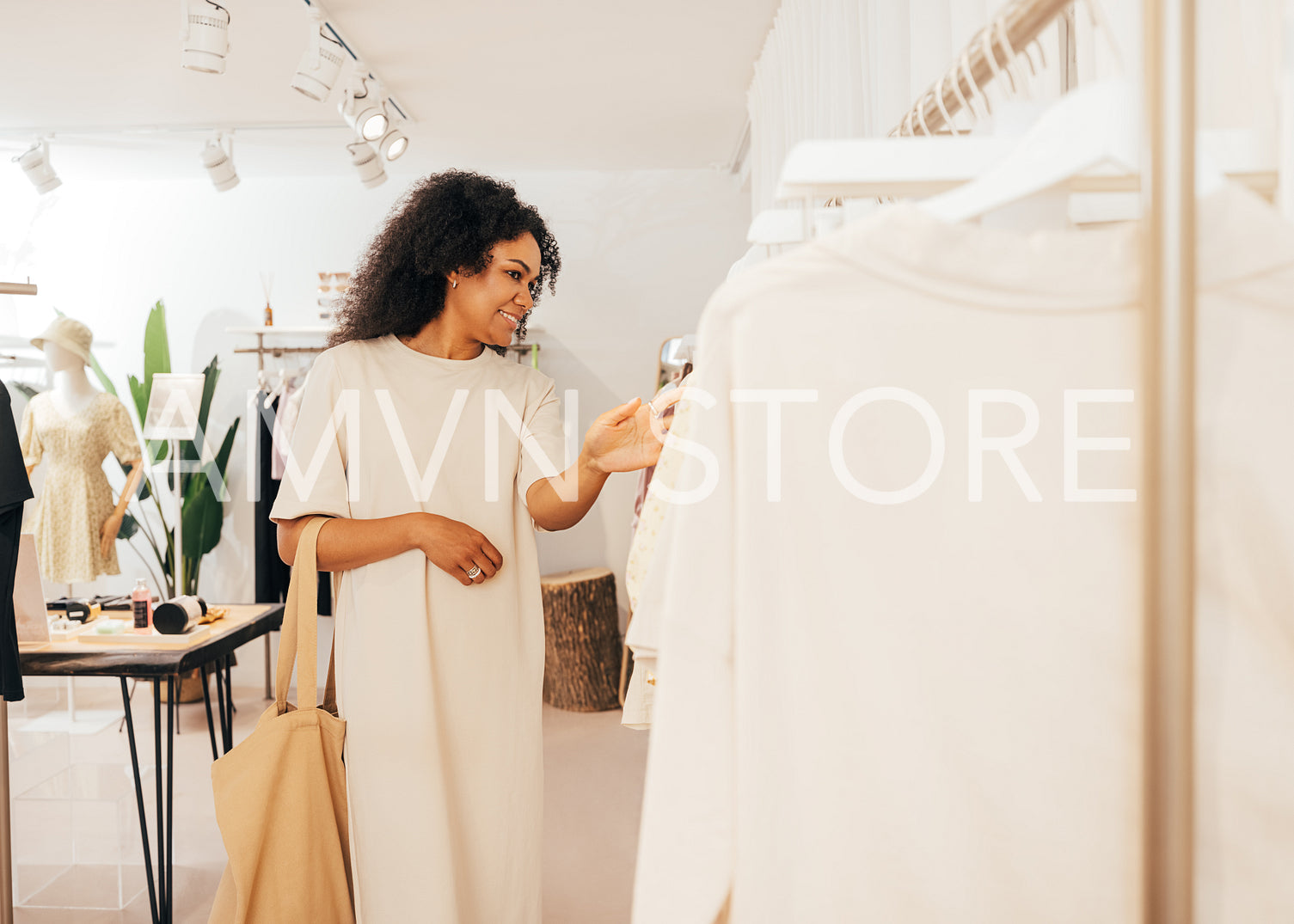 Side view of a fashionable woman looking for new clothes in smal