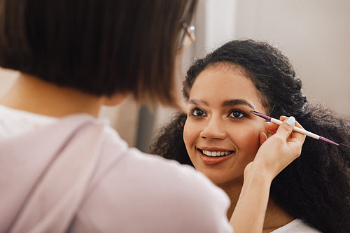 Makeup artist highlighting eyebrows of a model