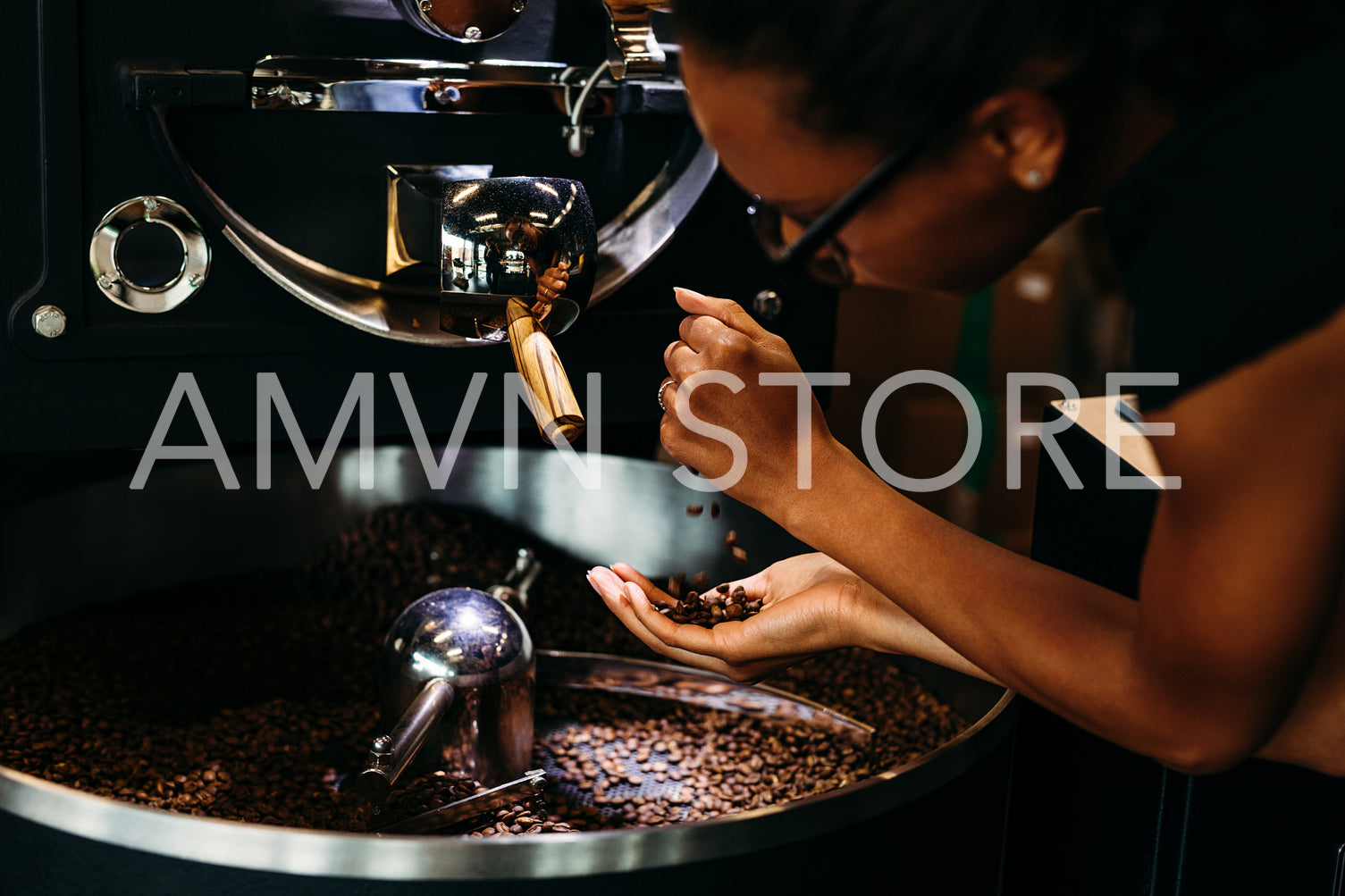 Woman controlling quality of coffee. Barista pouring beans from hand to hand.	