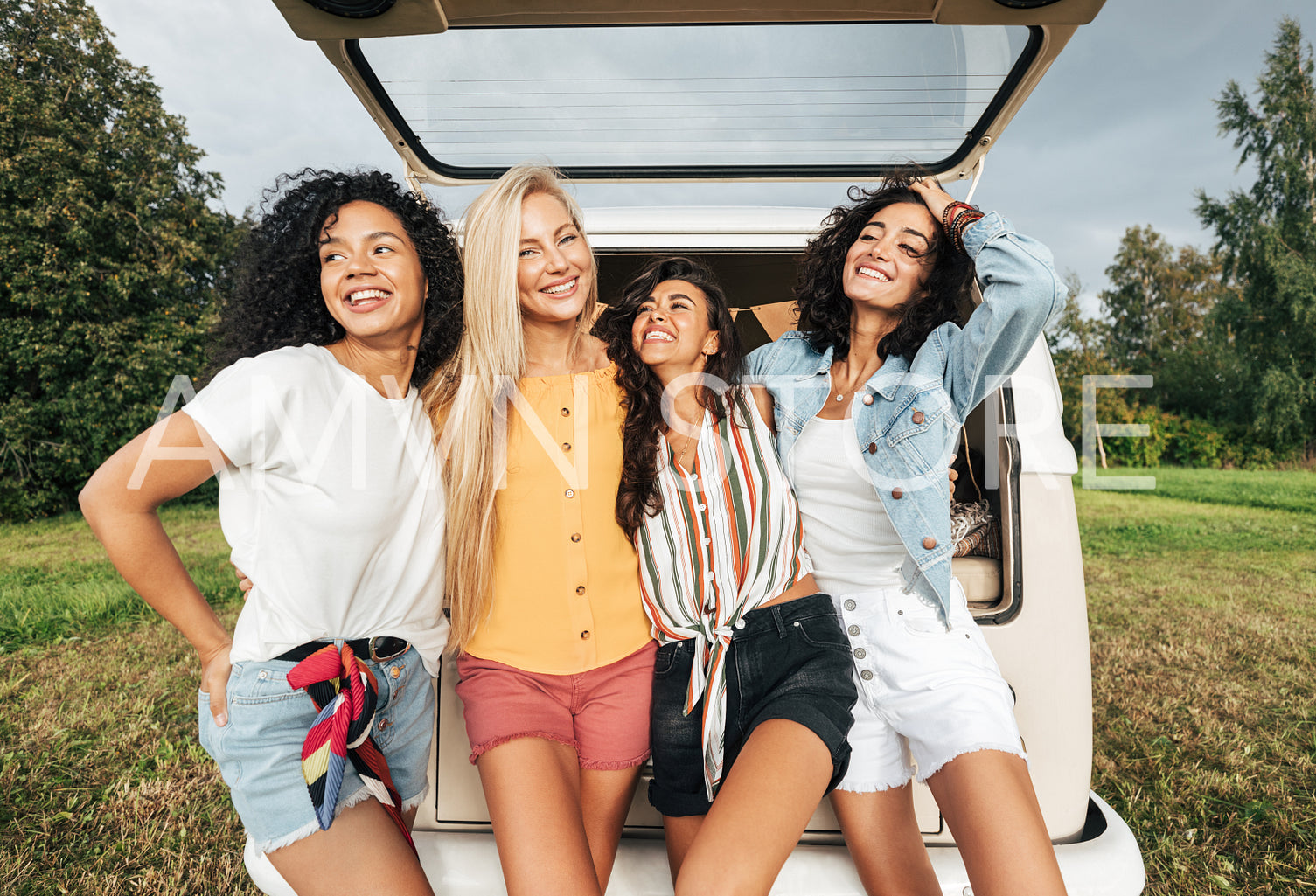 Group of four multi-ethnic women standing near a minivan 