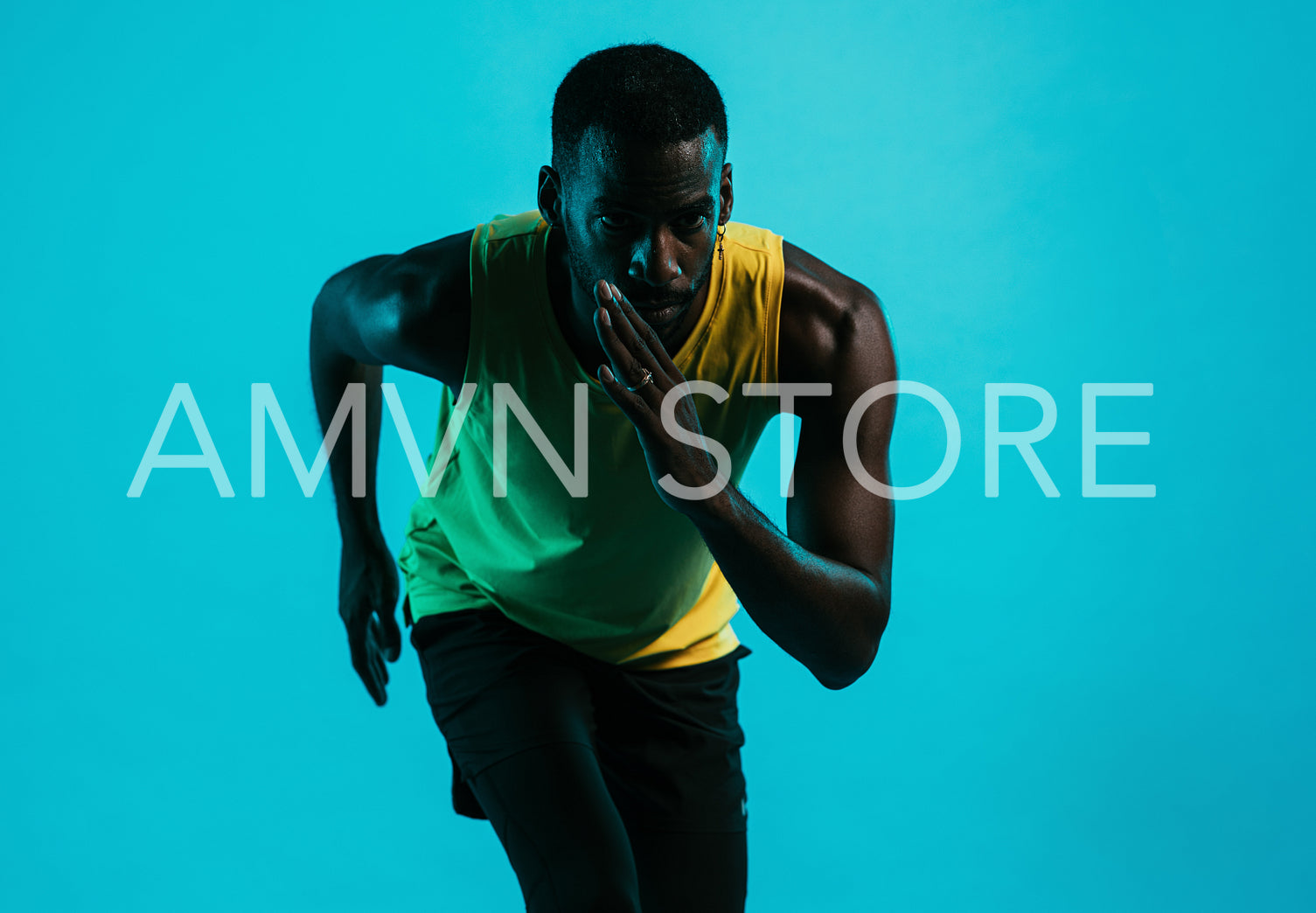 Portrait of an athlete against a blue background in position to start a run