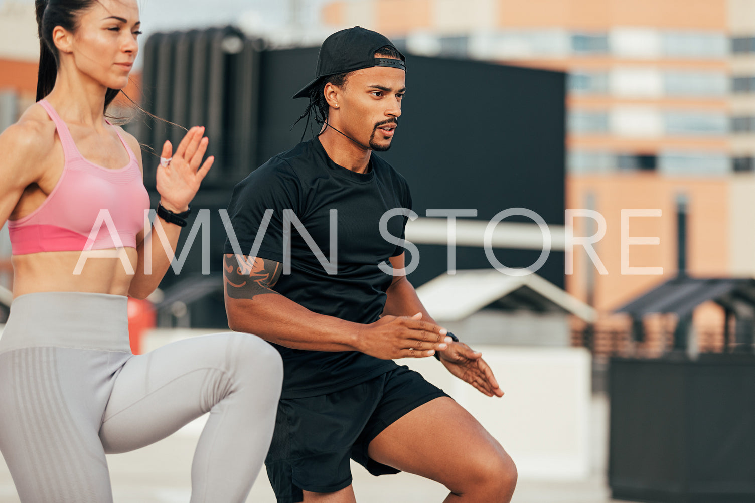 Fitness couple running together. Two people in sportswear exercising on rooftop.