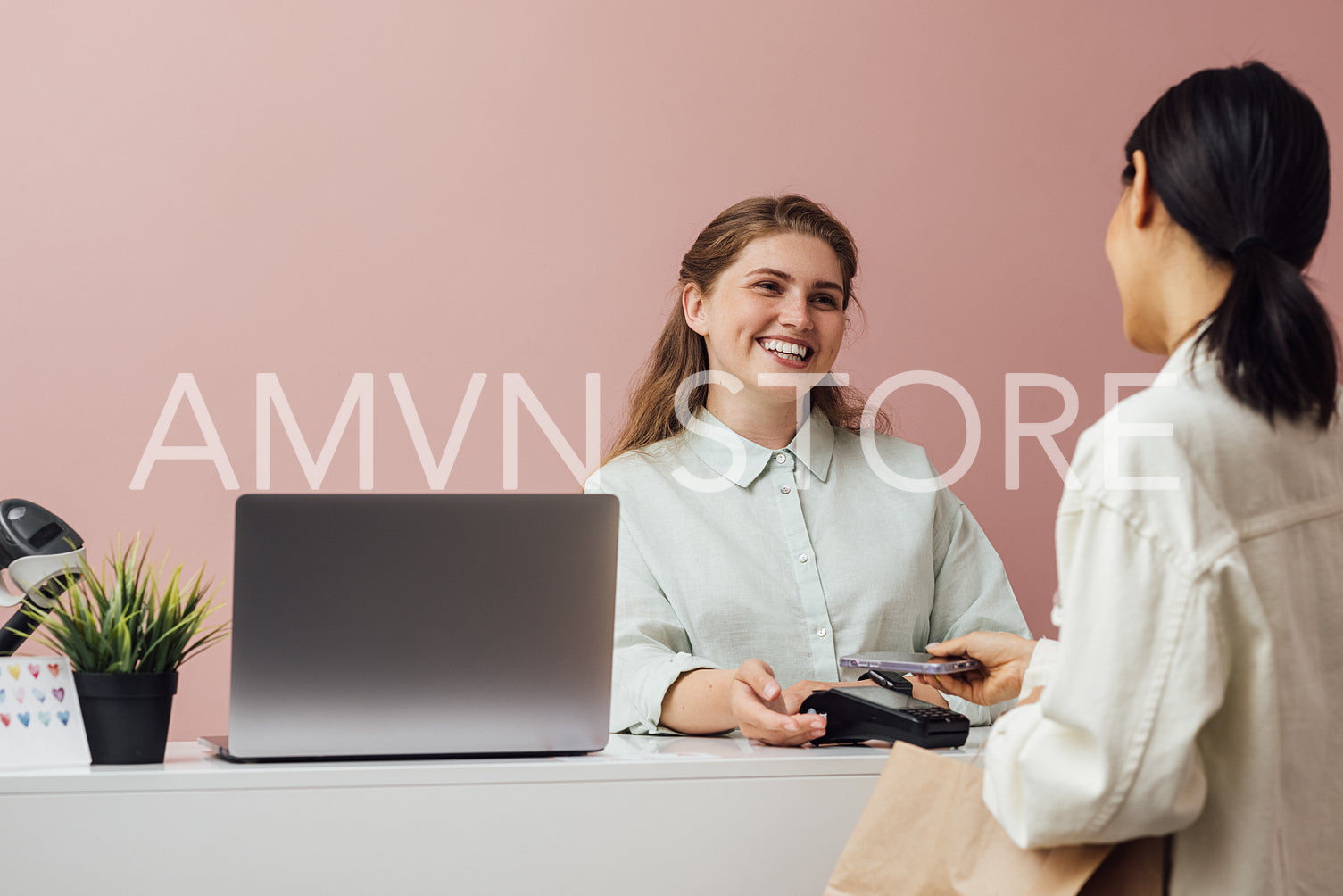 Cheerful clothing store owner receiving payment from customer at