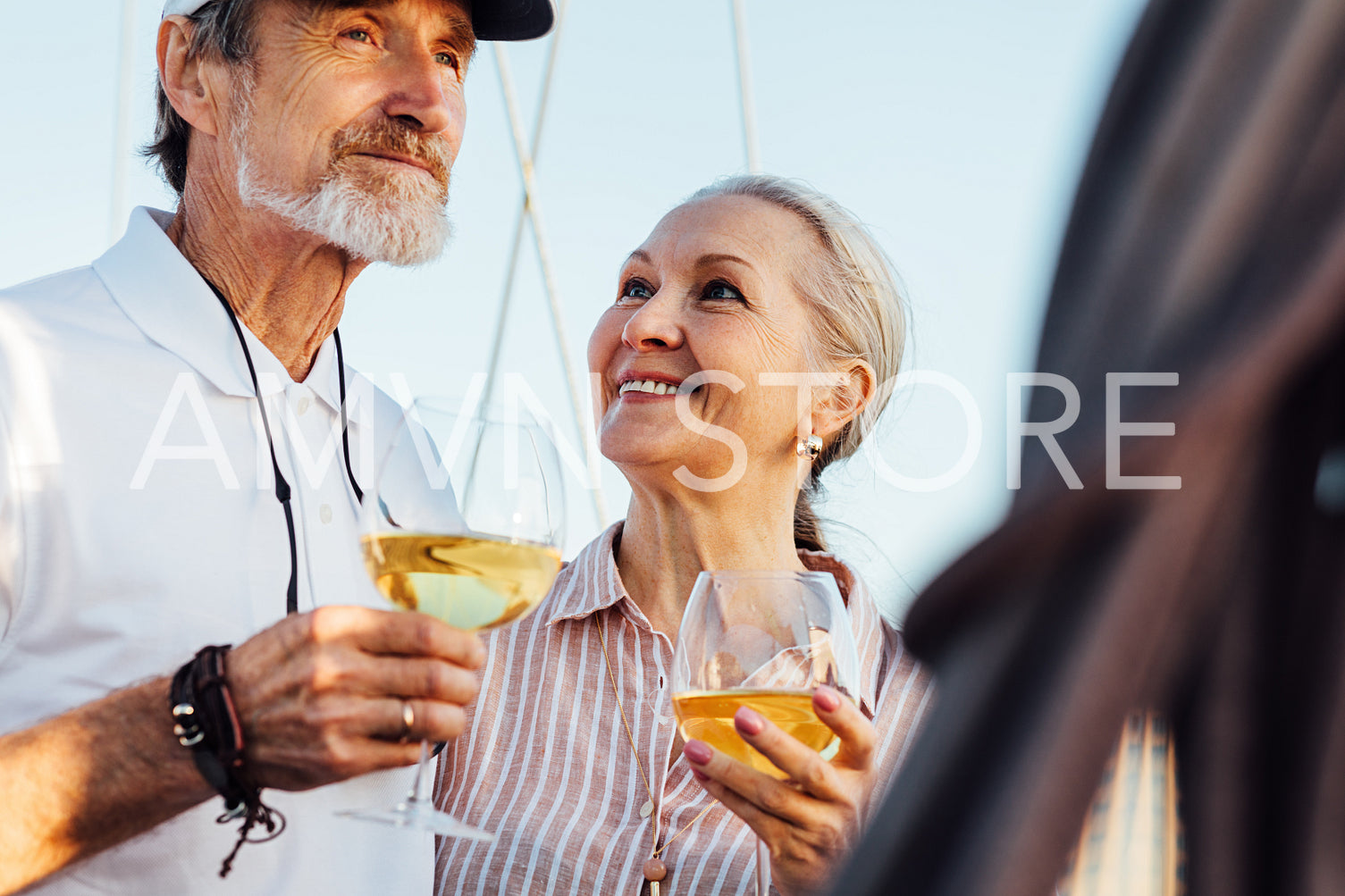 Mature couple drinking wine outdoors. Man and woman enjoying summer day.	