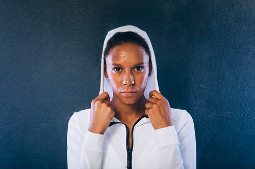 Young woman in sports clothes looking at camera. Confident and sweated sportswoman in studio.