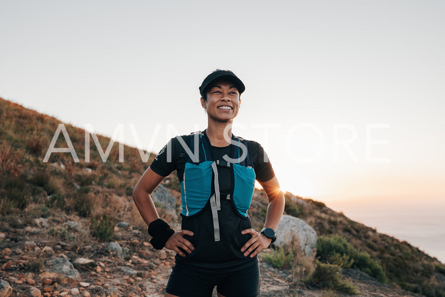 Smiling woman hiker relaxing during hike holding hands on waist