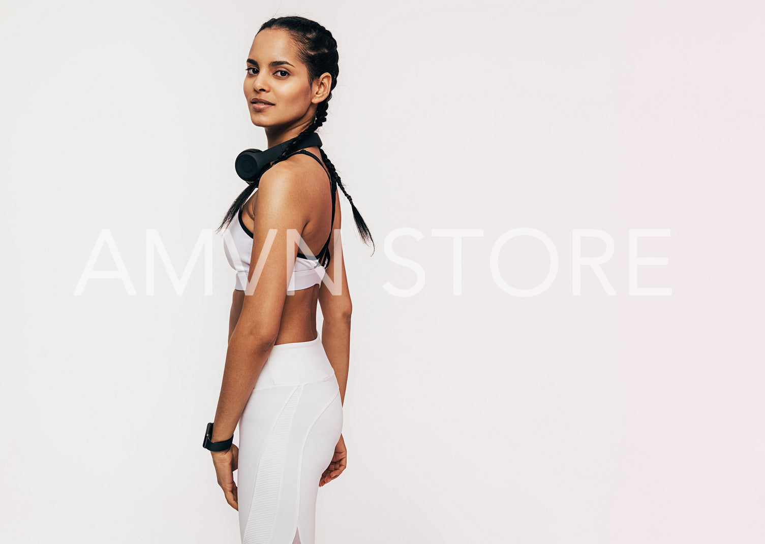 Beautiful mixed race woman in sportswear looking at the camera in a studio	