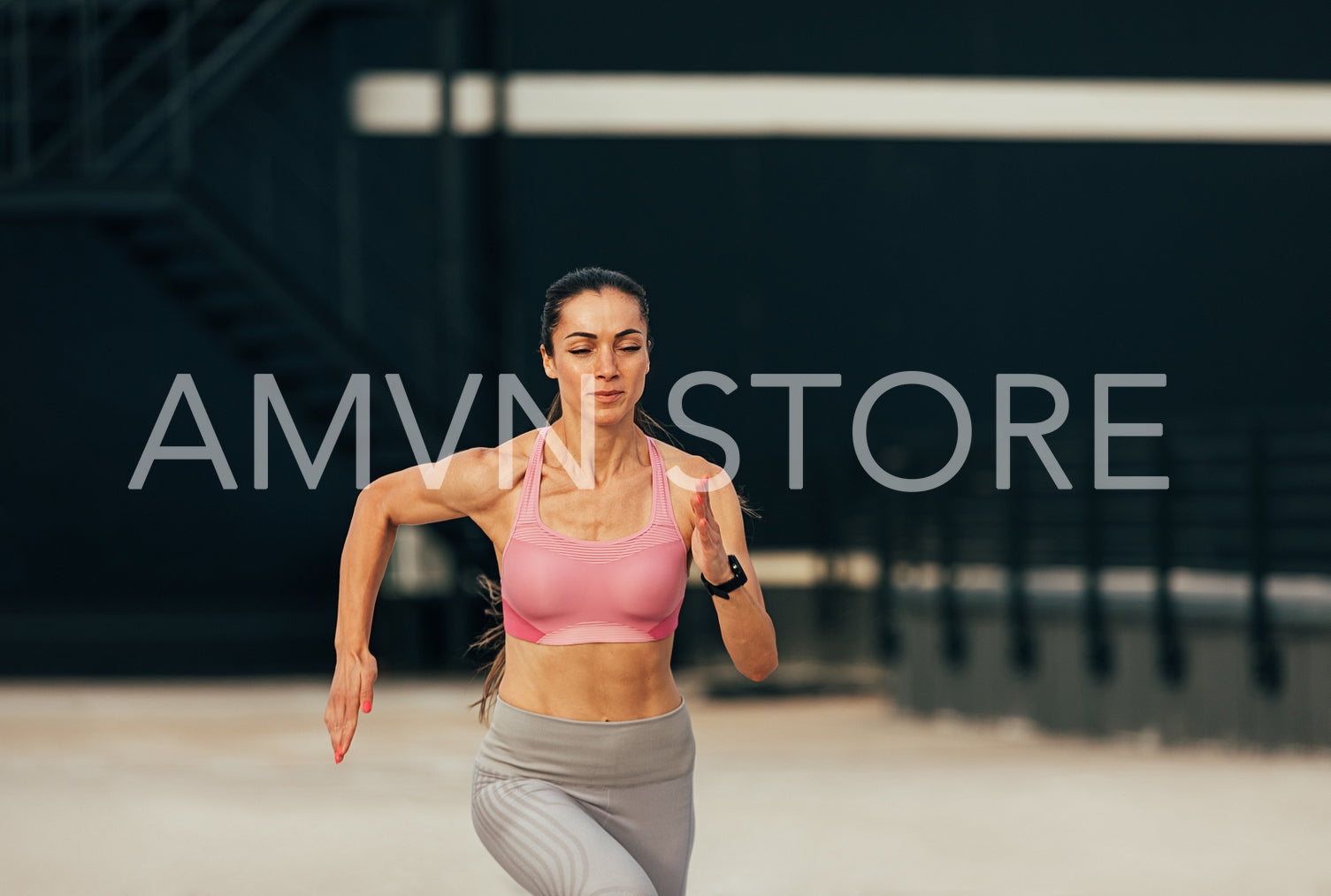 Young muscular runner on the roof. Female jogger exercising on rooftop.