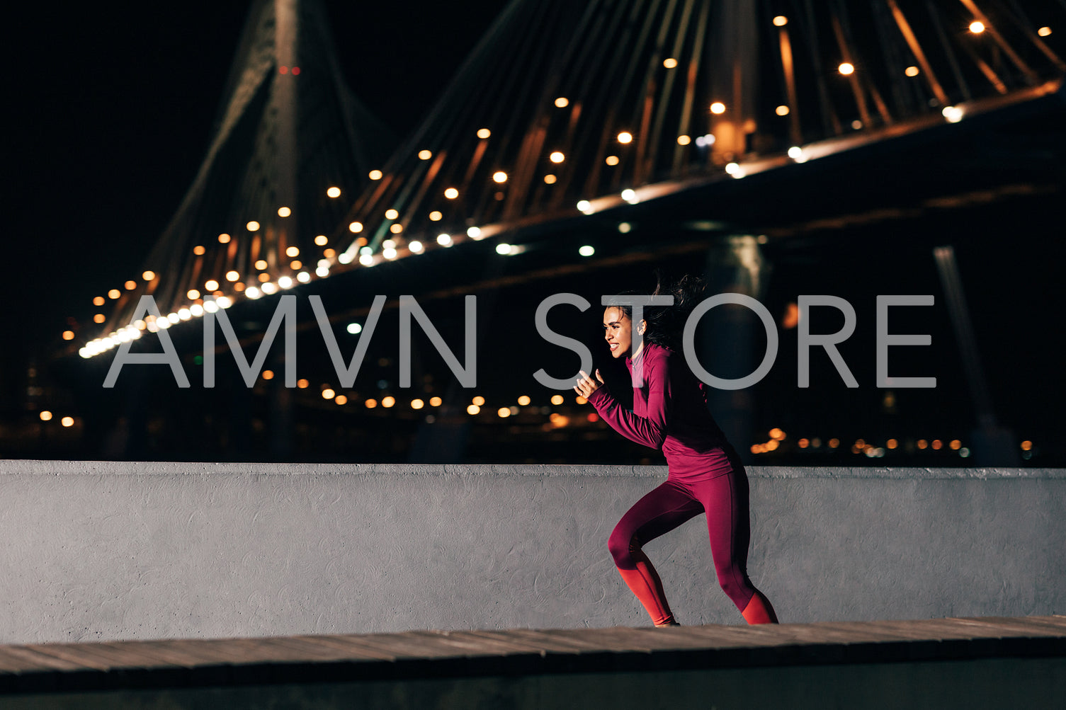 Female runner in sportswear exercising at night. Side view of a woman jogging outdoors at embankment.