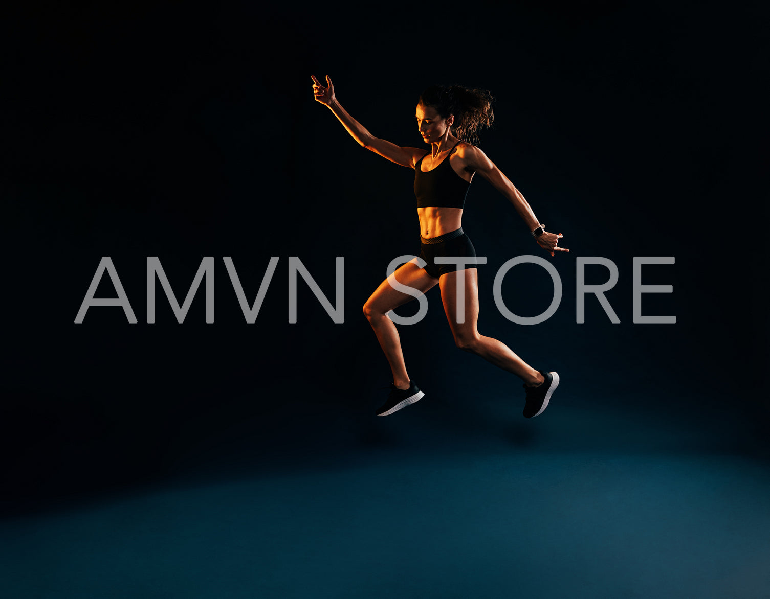 Slim woman in sportswear doing jumps on black background