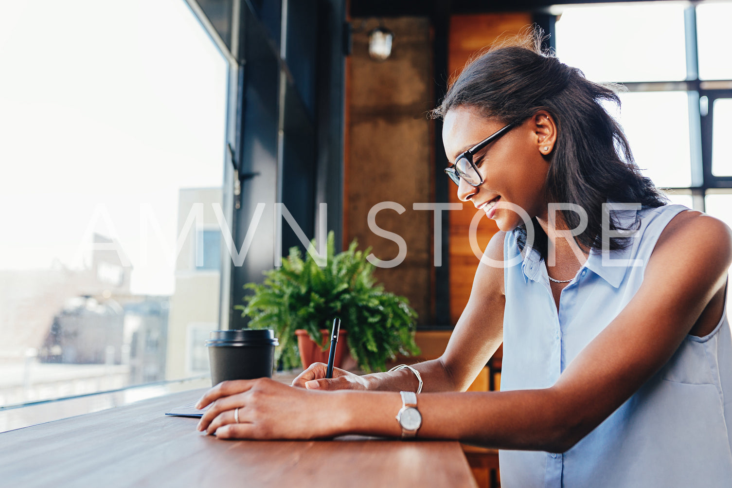 Businesswoman working on her project from cafe, writing on notebook	