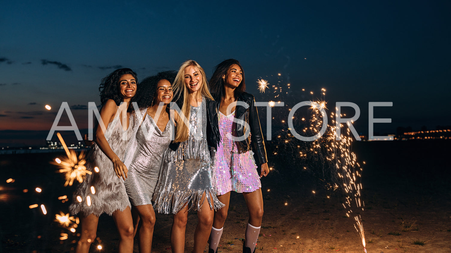 Four friends dressed up for party having fun outdoors at night	