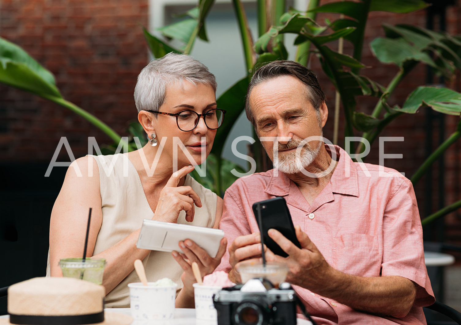 Mature couple using their smartphones while sitting outdoors