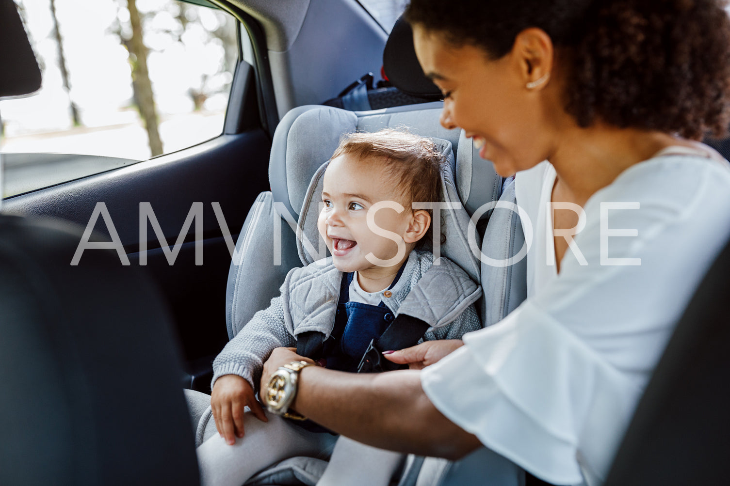 Happy little girl sitting on backseat and looking out of window	