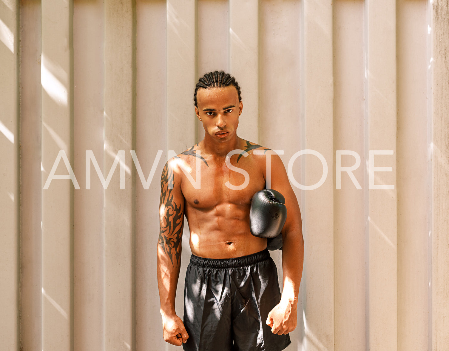 Young kickboxer standing at a wall after training looking at the camera	