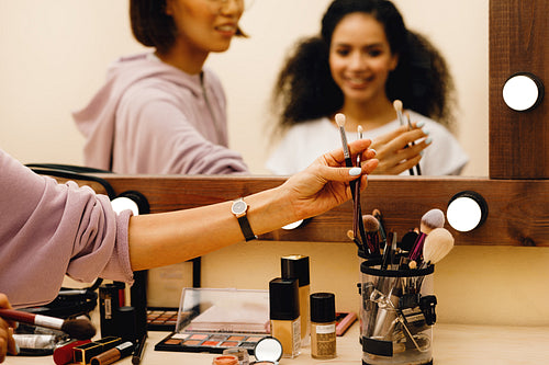 Hand of makeup artist picking up a brush