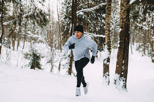 Young man doing morning training. Sportsman running up the hill.