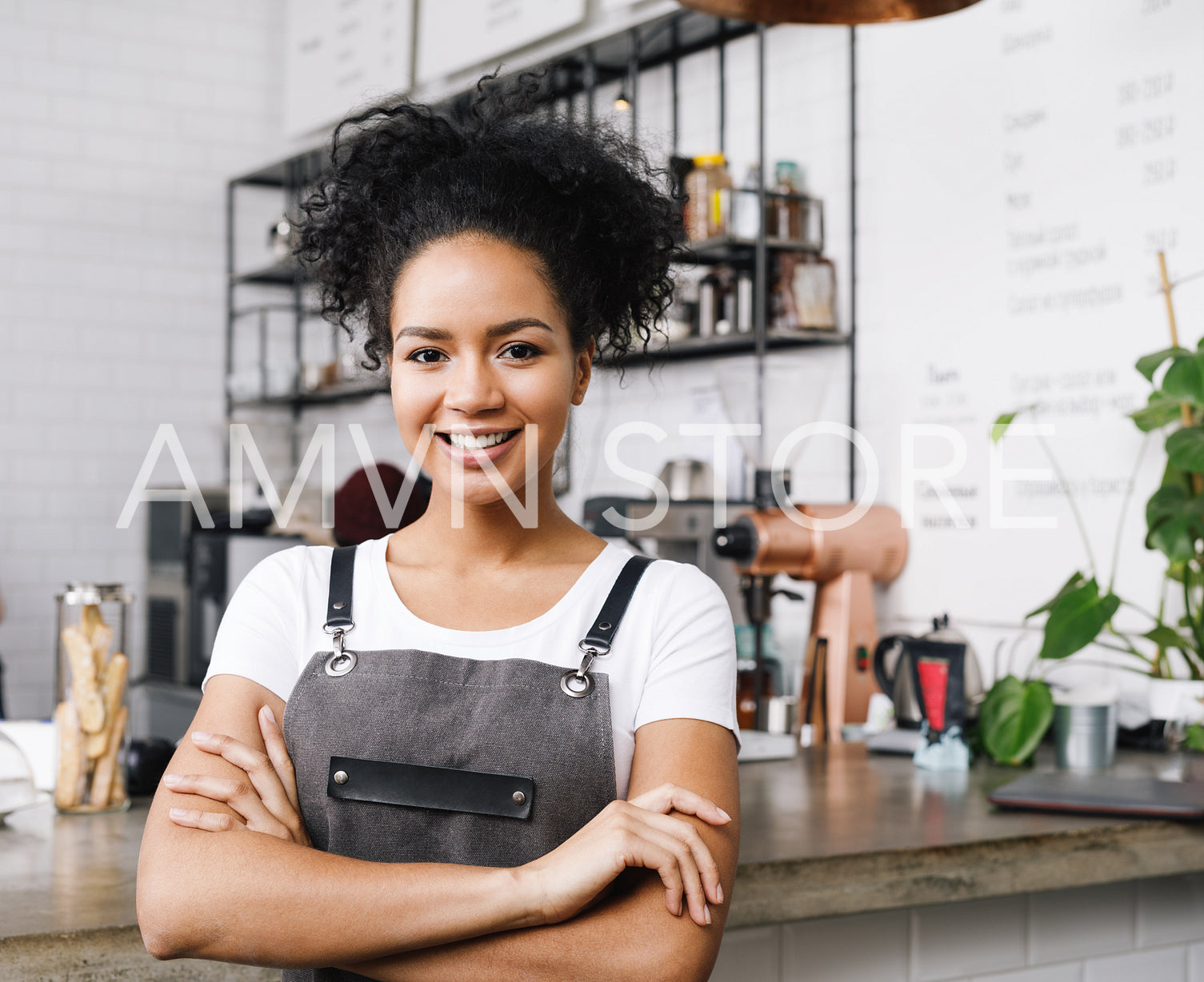 Cafe owner standing with arms crossed looking at camera	