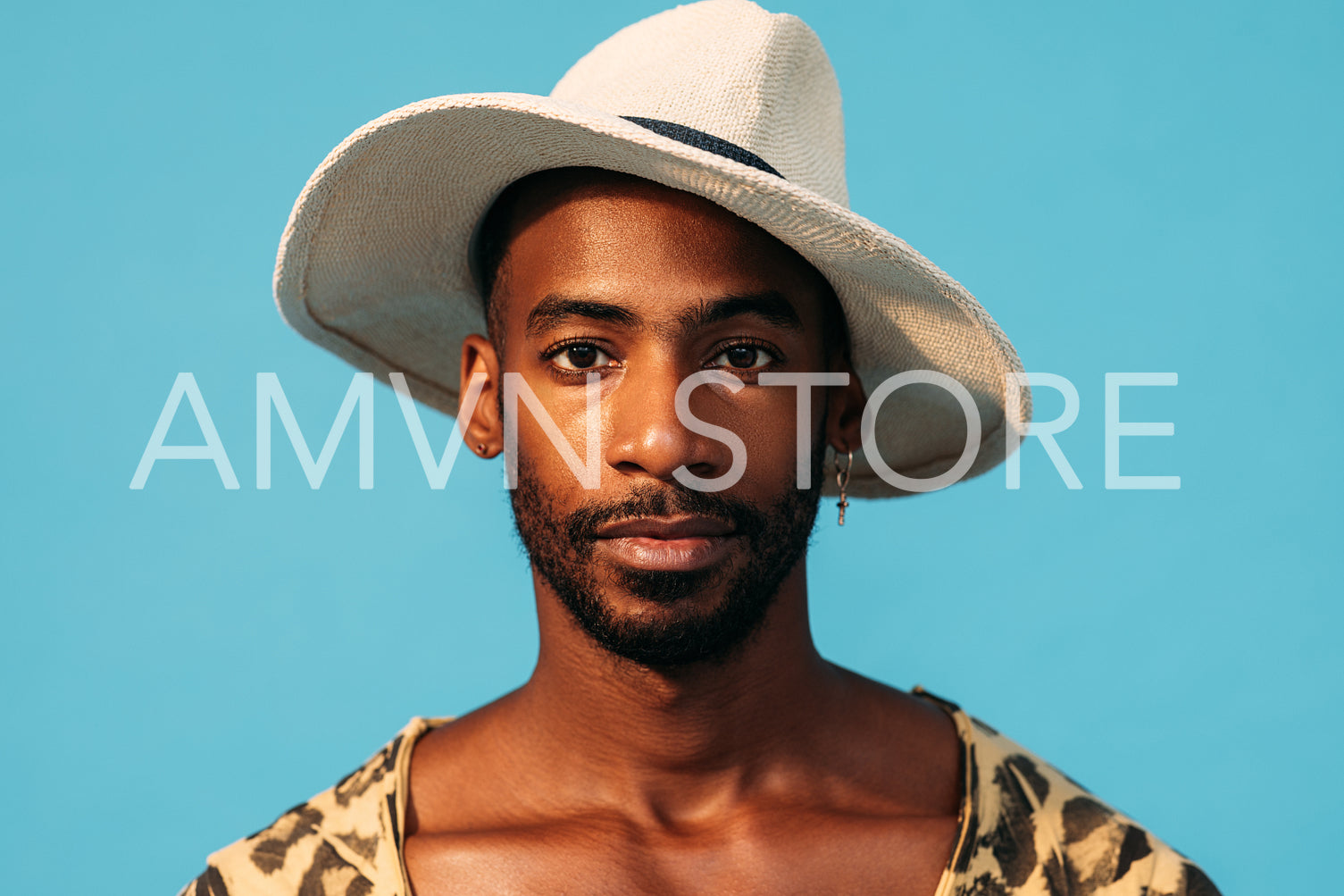 Close up portrait of a handsome man in hat against a blue background