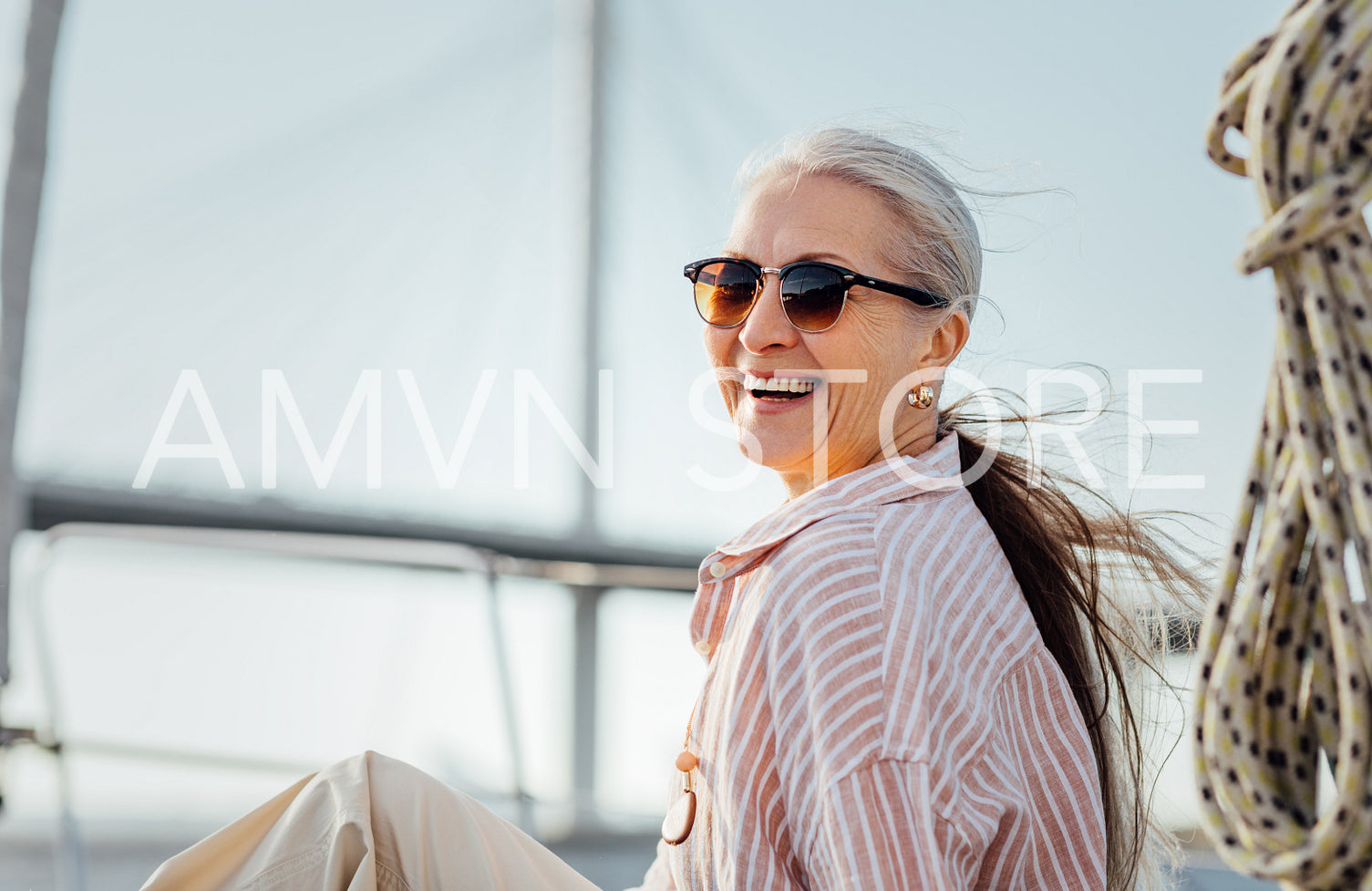 Laughing mature woman wearing sunglasses and looking at camera. Smiling female in casuals enjoying vacation.	