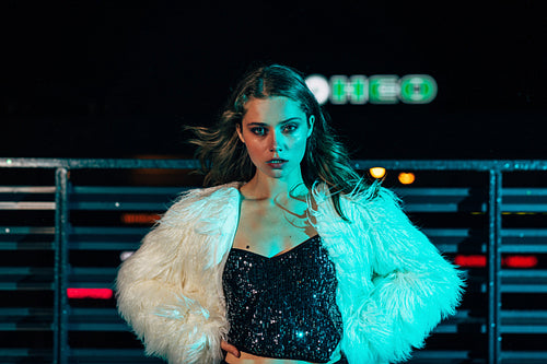 Portrait of a stylish blond woman at night looking at camera