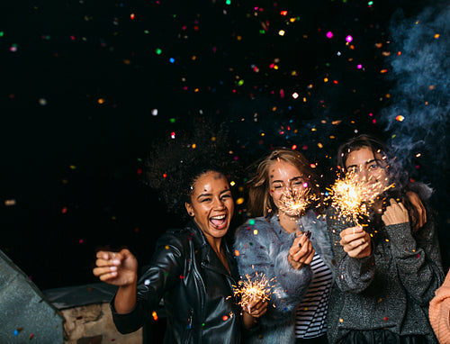 Group of happy friends celebrating new year's eve with confetti and sparklers	HU9A0828done.jpg