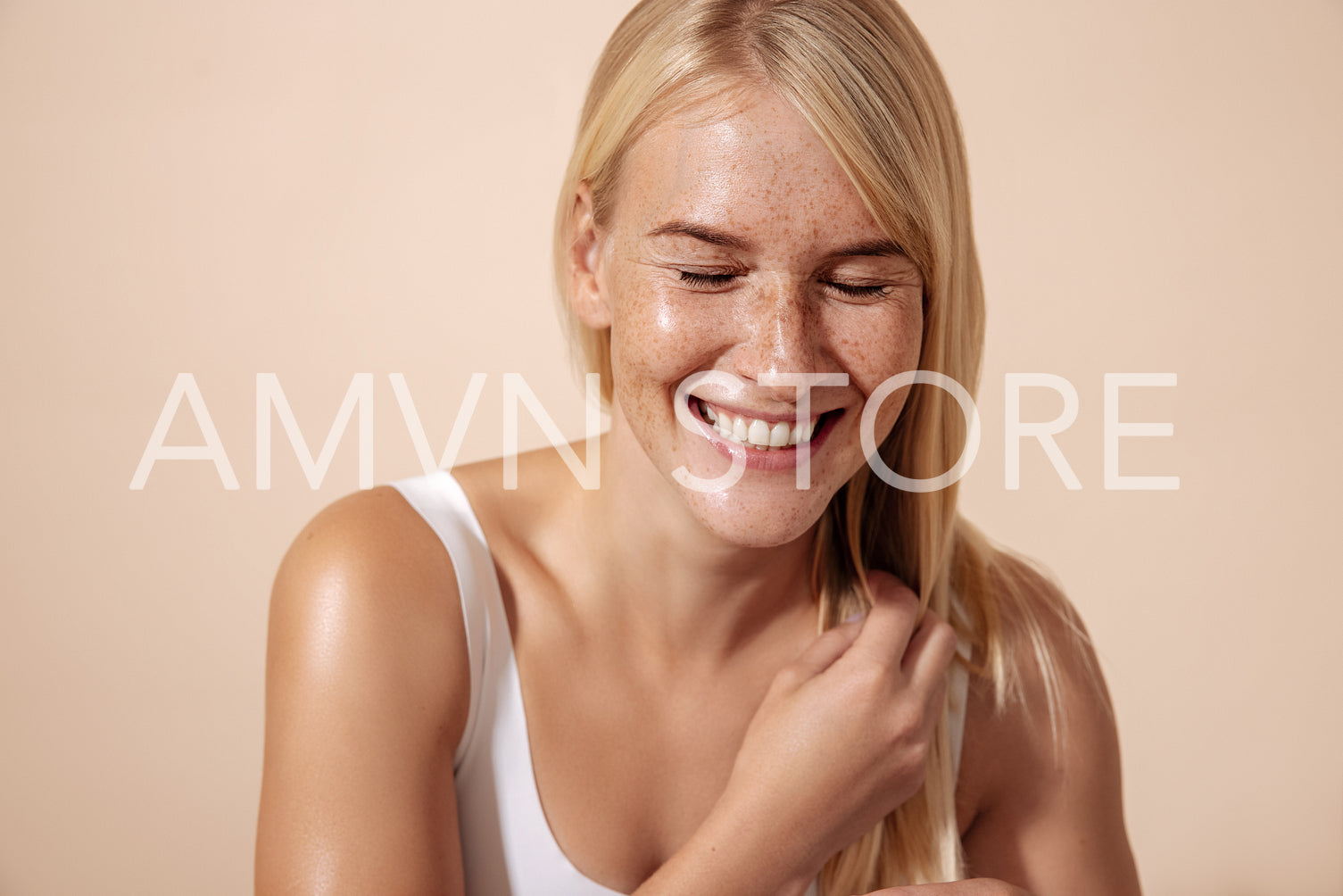 Studio shot of a happy caucasian woman adjusting her hair with c