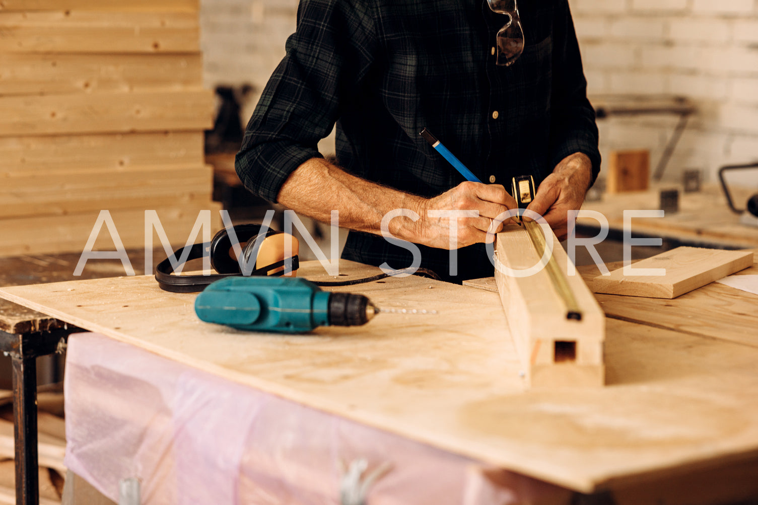 Cropped shot of caucasian mature carpenter measuring a wooden plank in workshop	