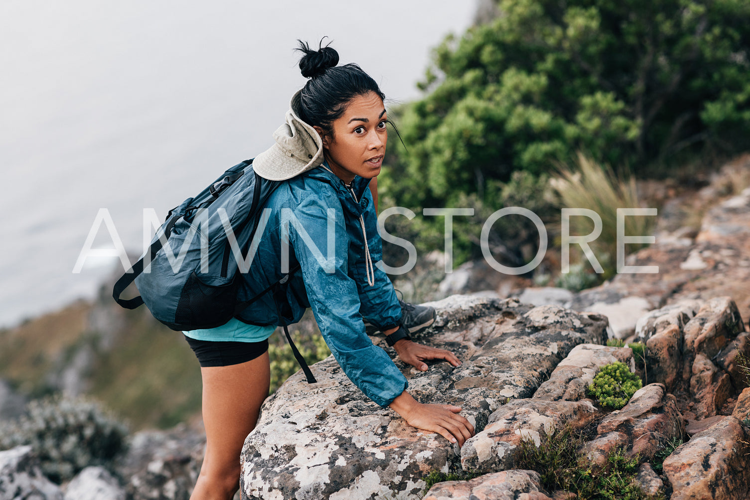 Young woman on a hike. Female hiker climbing up.