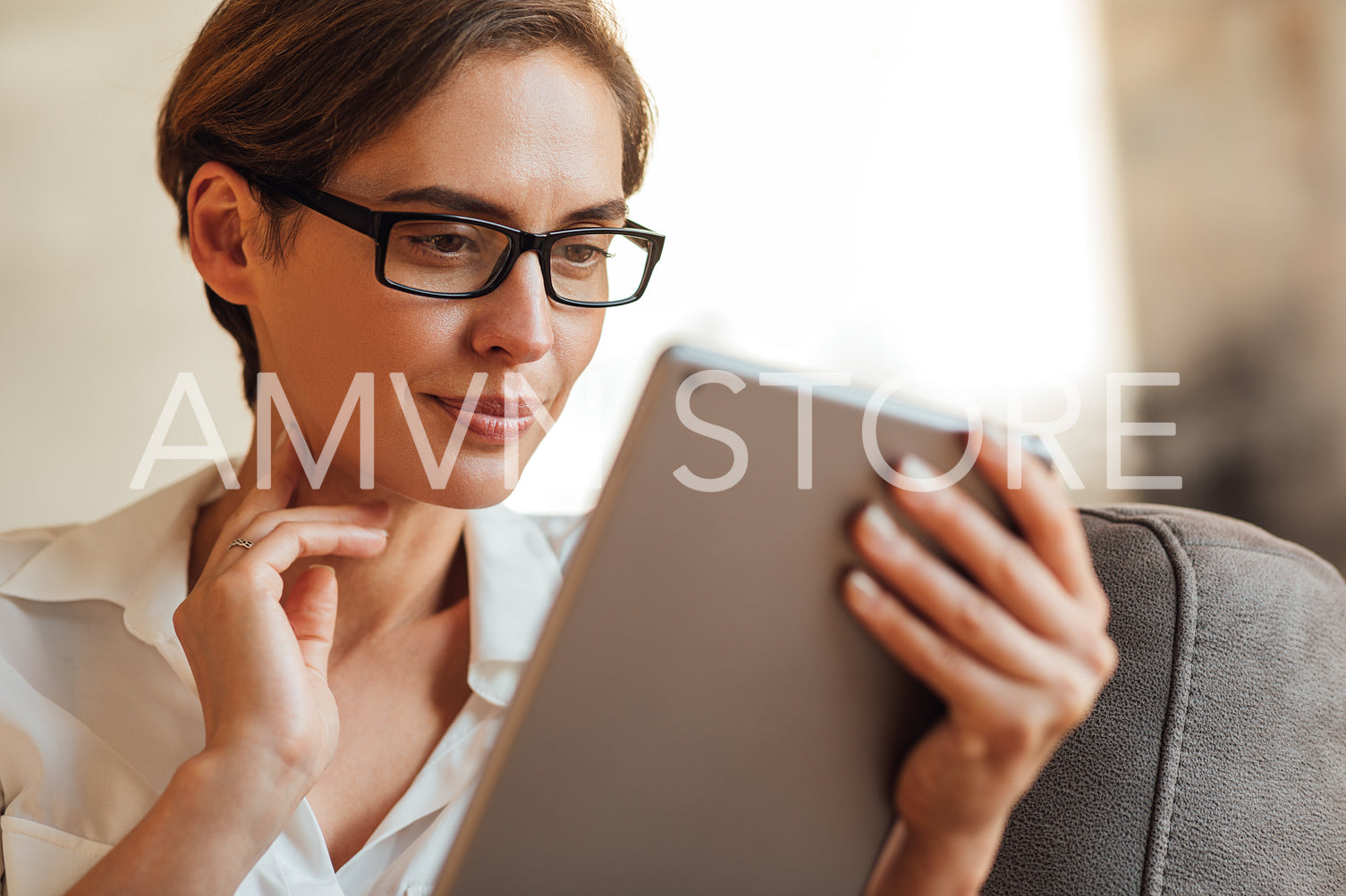 Close-up of a businesswoman in eyeglasses using a digital tablet. Portrait of a female with a digital tablet.