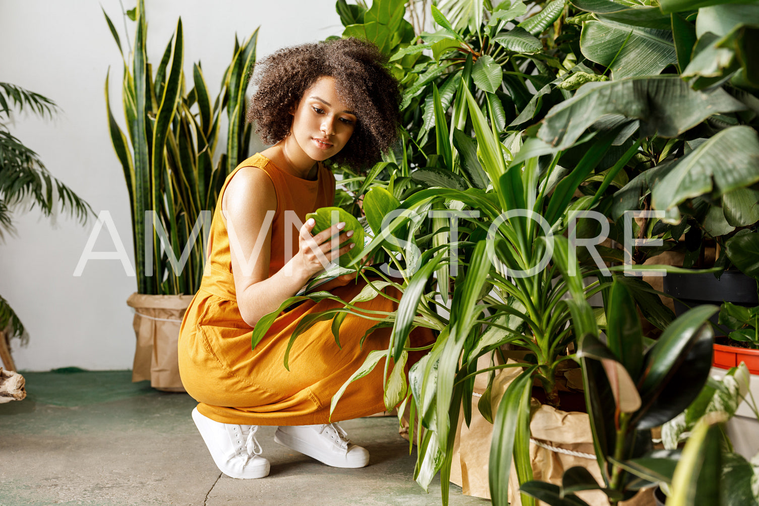 Young woman holding a book and observe a plant in workshop	