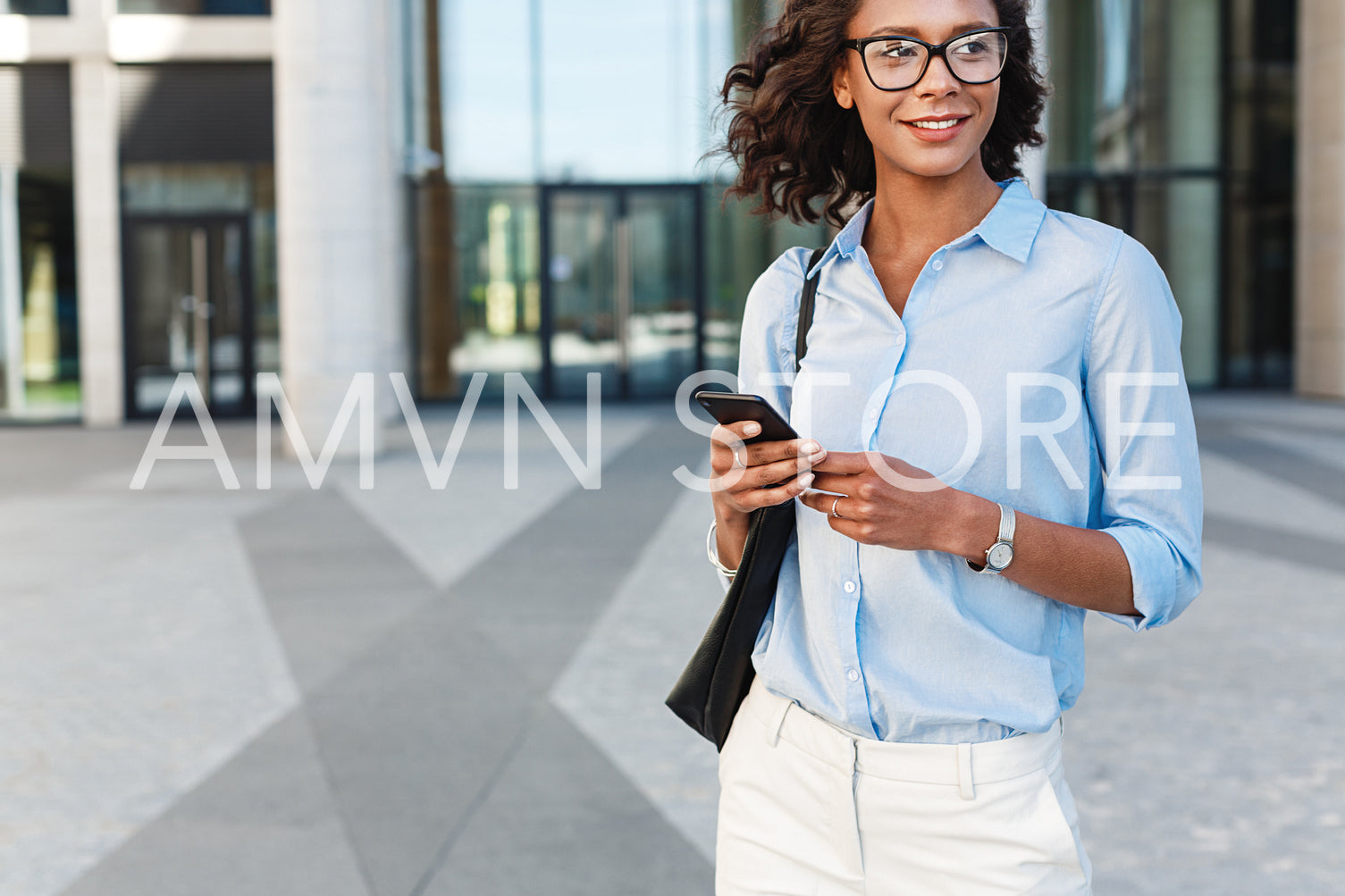 Business person holding a mobile phone and looking away	