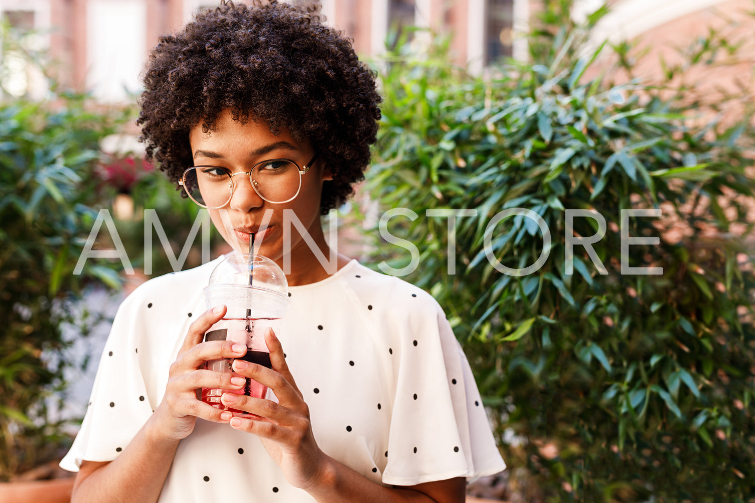 Portrait of a beautiful girl drinking juice with a straw	