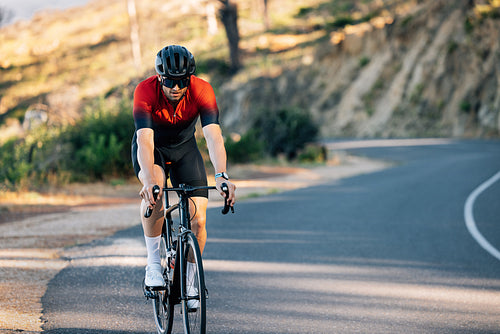 Cyclist in a helmet and glasses rides a bike down the road