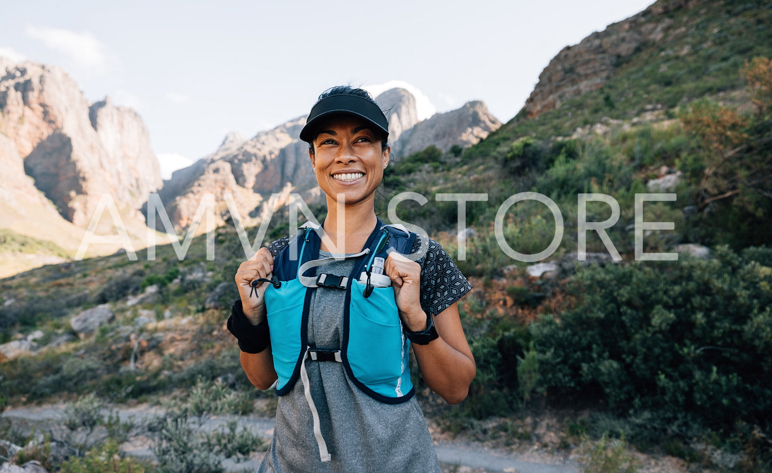 Portrait of a happy trail runner standing in wild terrain