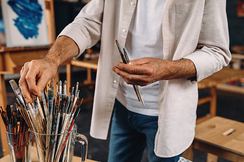 Cropped shot of artist choosing perfect paintbrush for a masterpiece